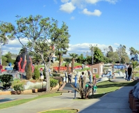 Family playing miniature golf at Boomers Irvine on a sunny day
